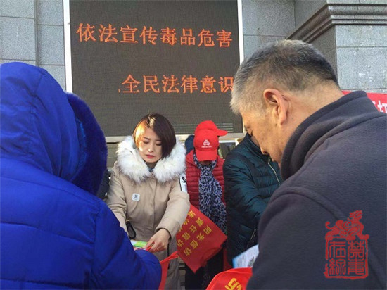 北七家禁毒社工兰志伟向来往群众发放禁毒宣传手册