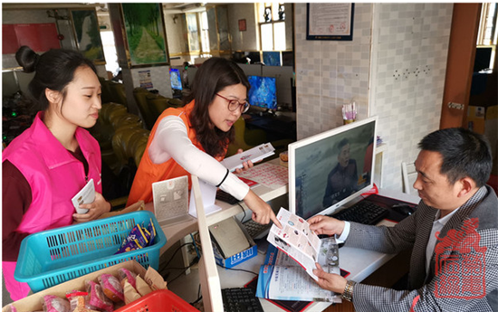 图为禁毒社工向网吧商户发放禁毒折页