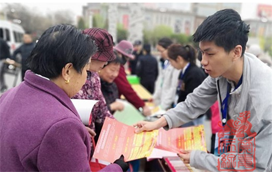 图为工作人员正在向市民发放禁毒宣传单